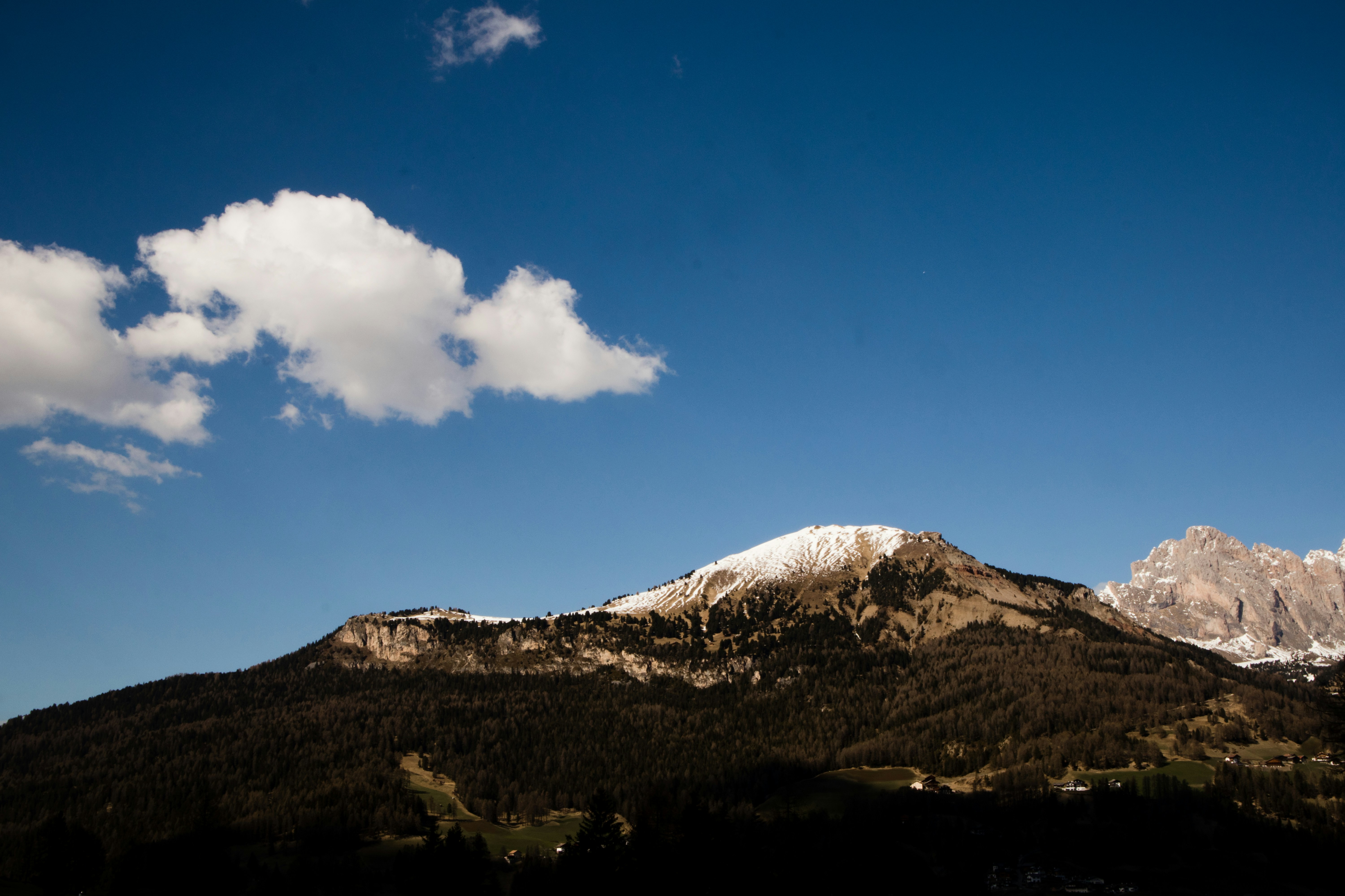 a snow covered mountain with a cloud in the sky