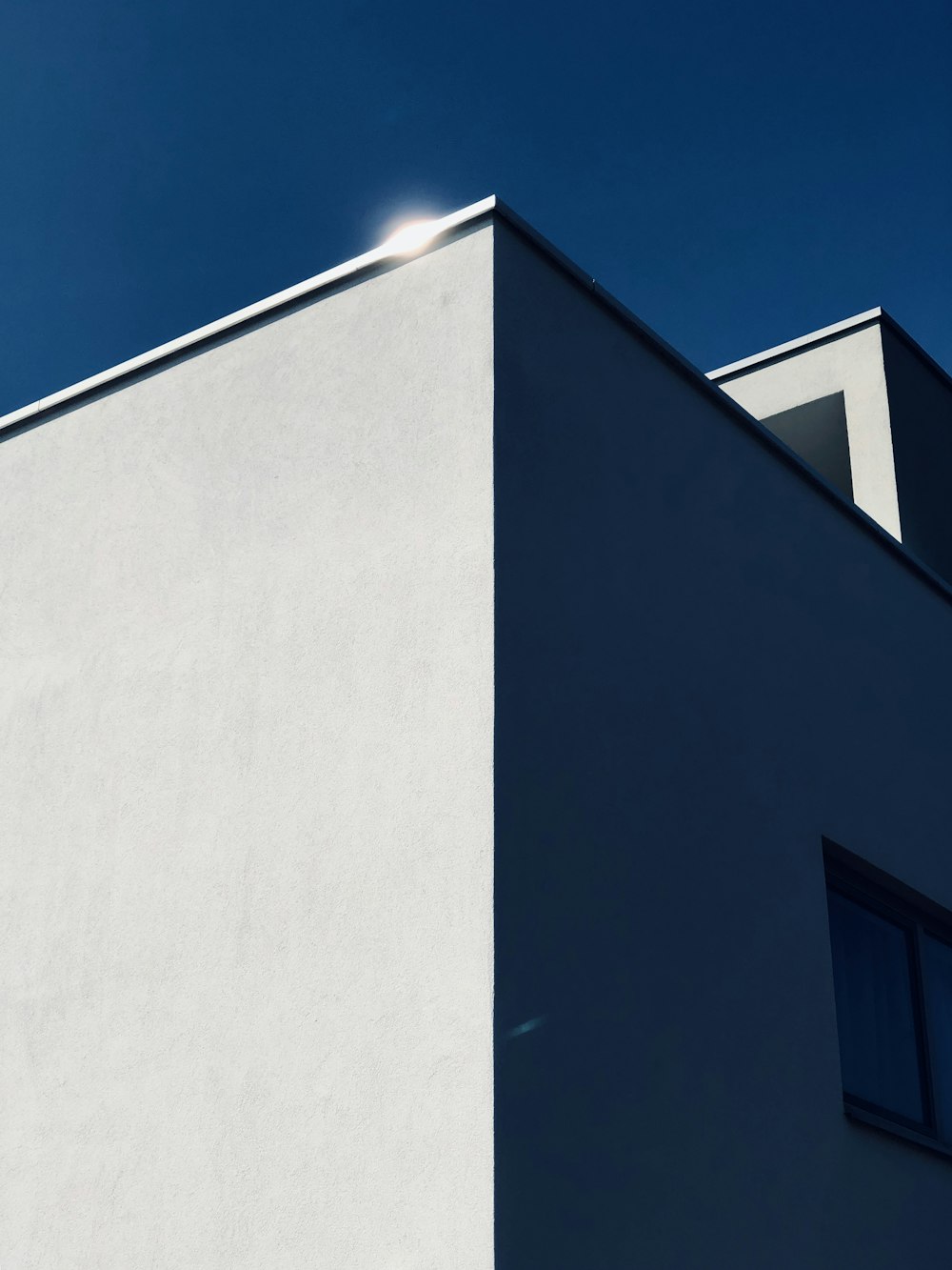 Fotografía de ángulo bajo de un edificio de hormigón bajo el cielo azul