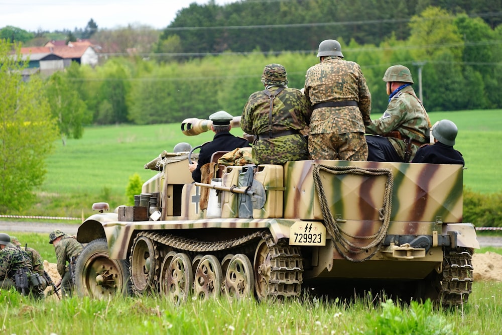 men riding on battle tank