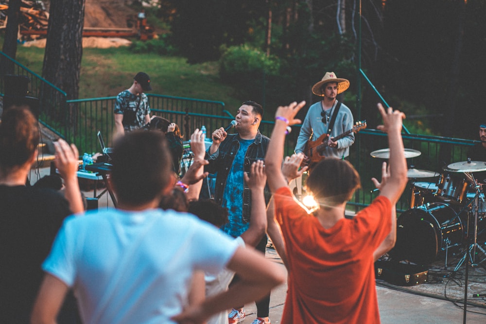 people playing with instruments near railings surrounded by people