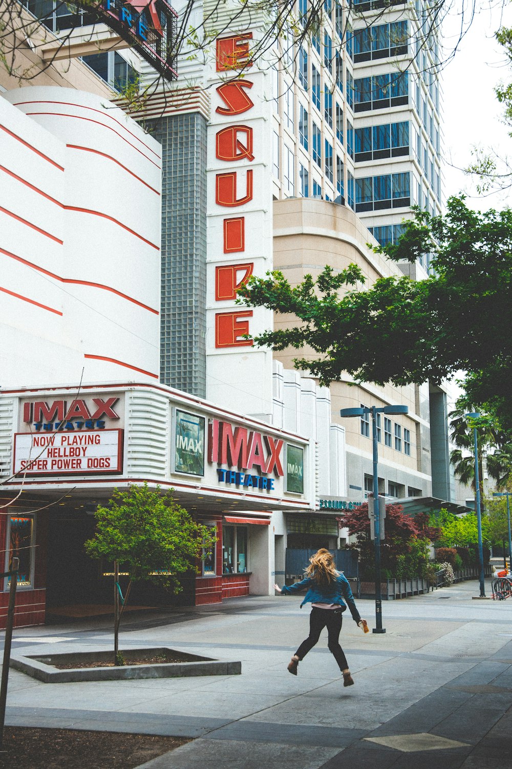 woman in blue jacket and b lack pants near Imax