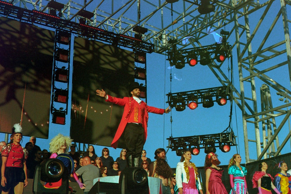 man in red coat standing in front of crowd