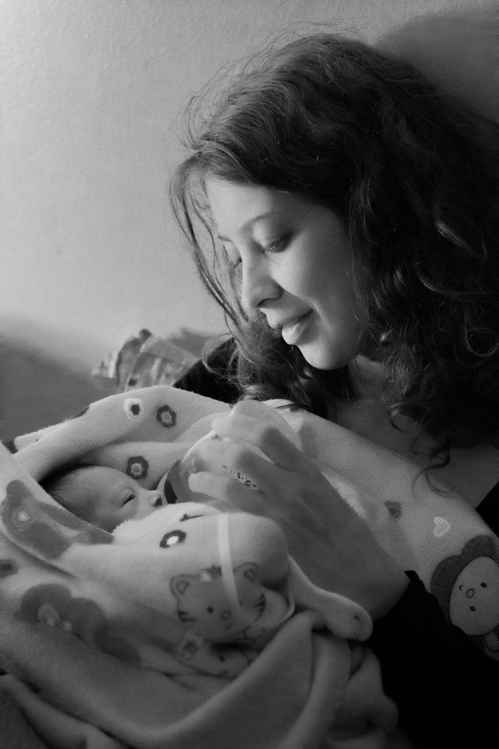 woman feeding baby through feeding bottle