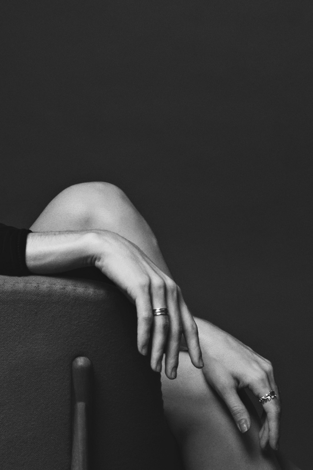 grayscale photography of sitting person wearing rings with both hands