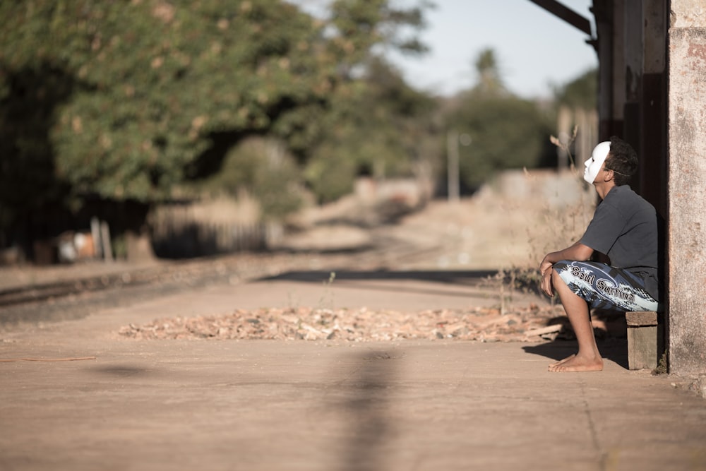 man wearing mask sitting on bench