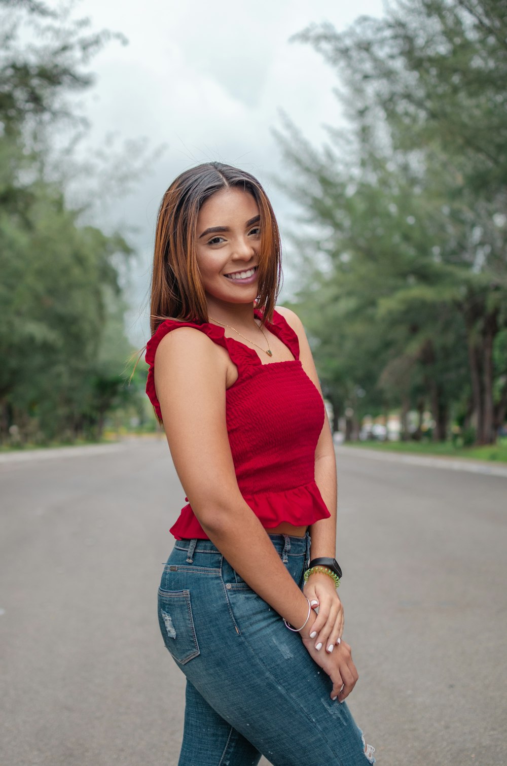 woman in red sleeveless top standing on road