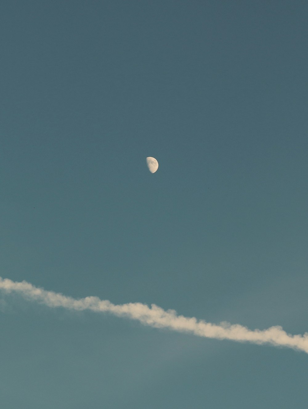 a plane flying in the sky with a contrail behind it