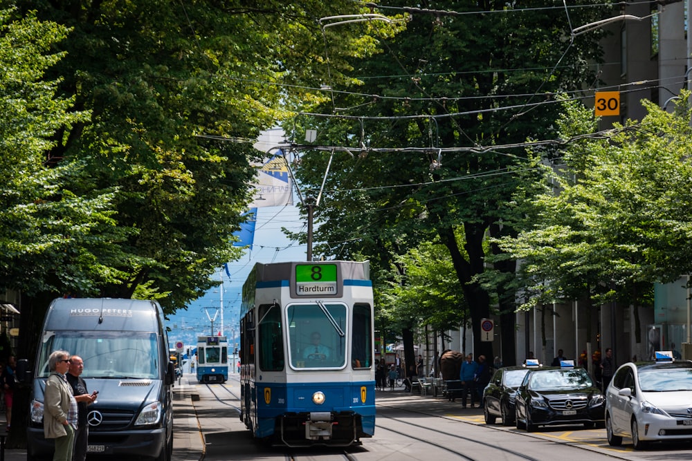 tram passing by several vehicles