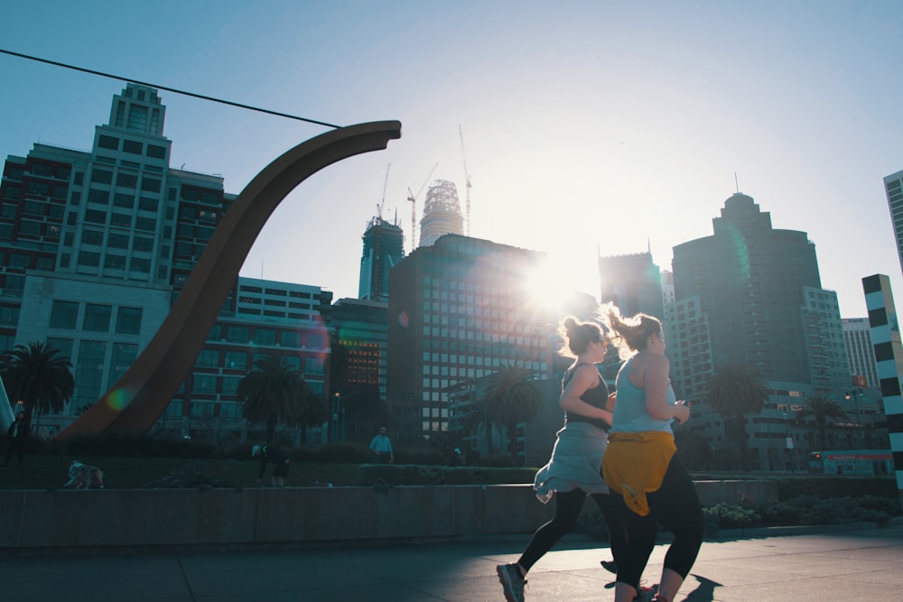 two women jogging on road near buildings