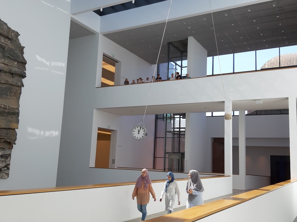 three women walking inside concrete building