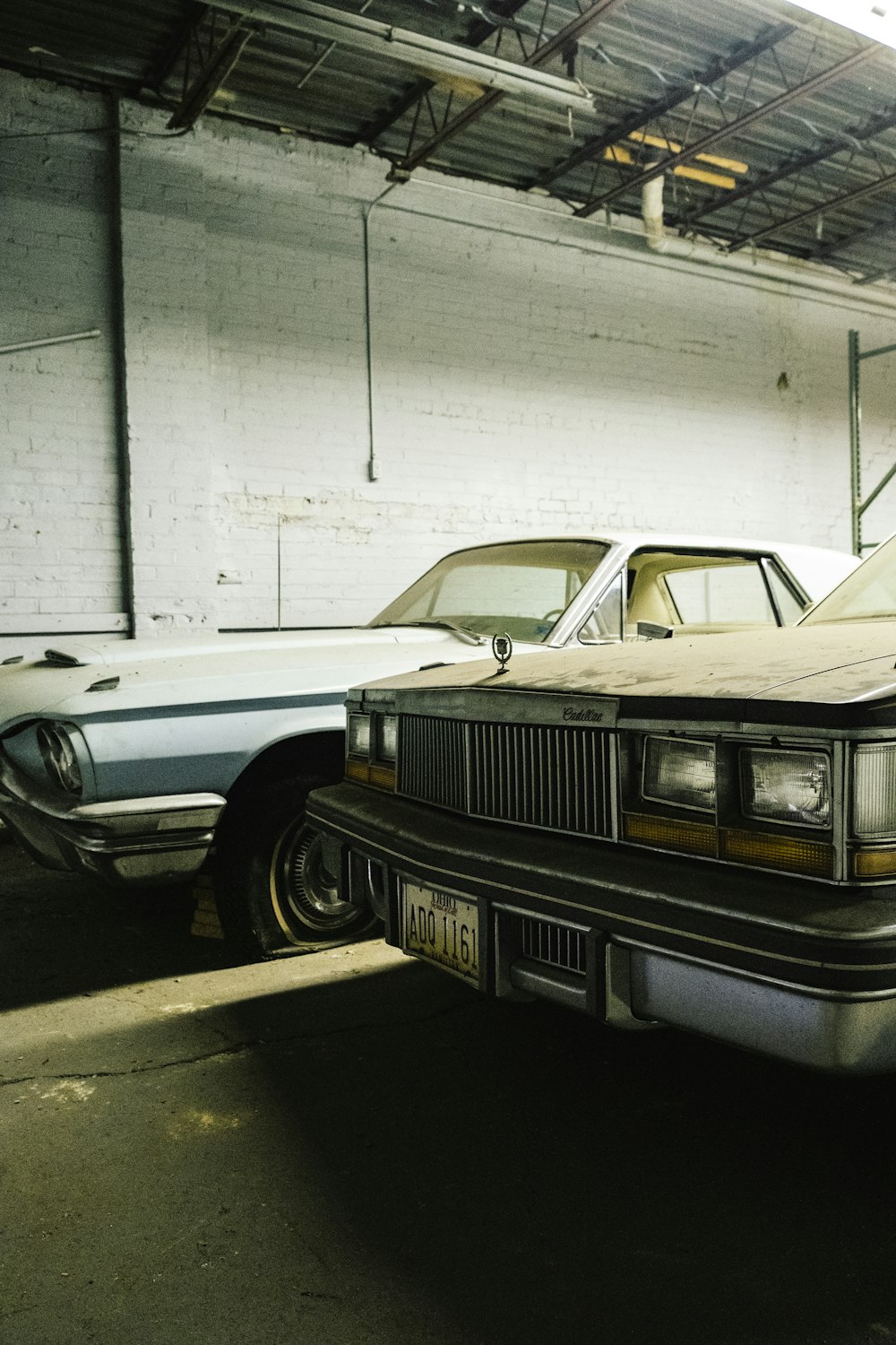 two white vehicles parking inside building