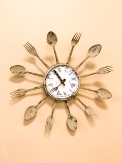 beige and white spoon and fork framed clock displaying 7:55