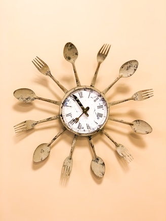 beige and white spoon and fork framed clock displaying 7:55