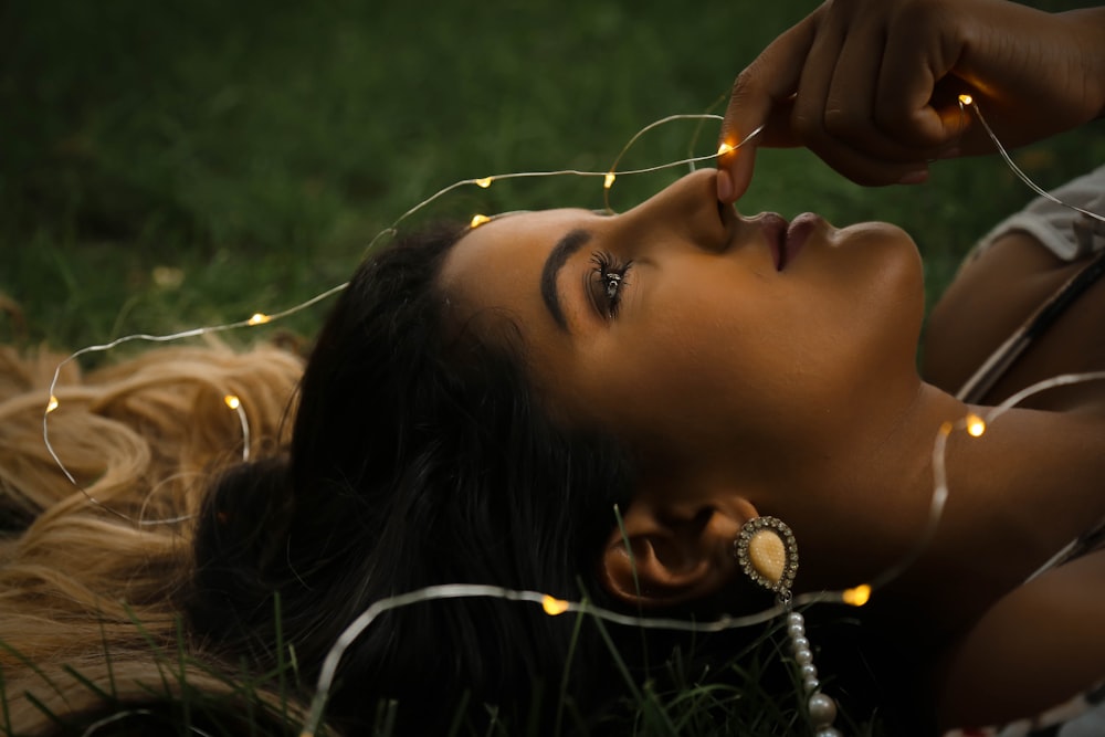 woman holding string lights