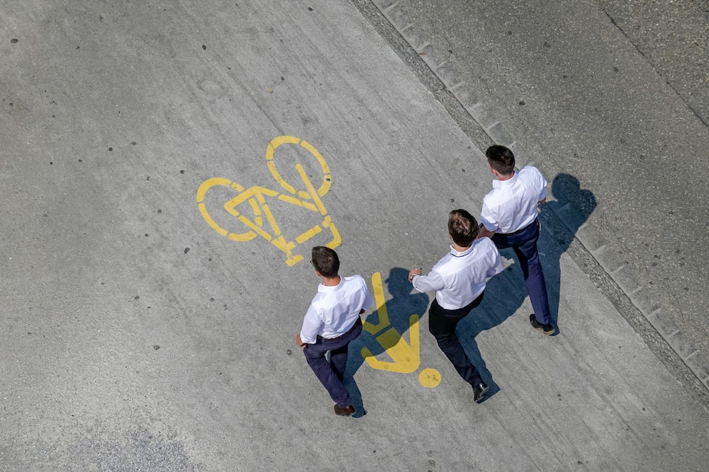 three men wearing white dress shirt and black dress pants walking side by side