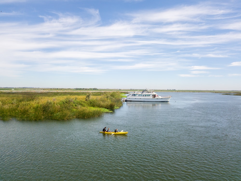 Kayak amarillo cerca de un yate