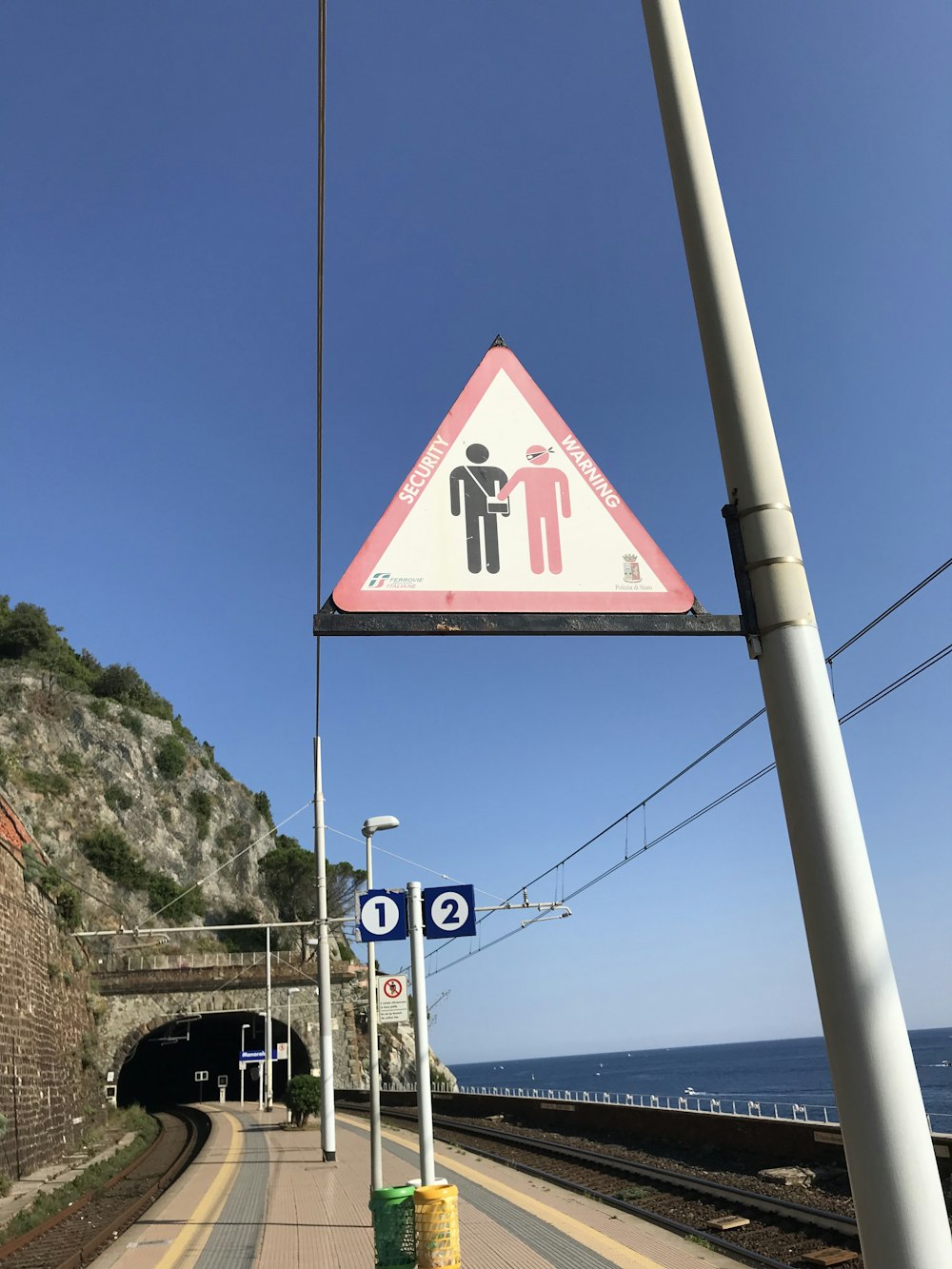 red and white street signage near body of water