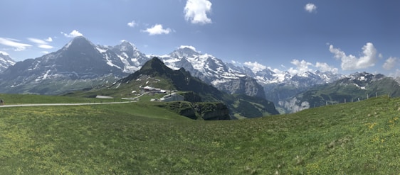 A panoramic view of snow-capped Himalayan peaks with a winding mountain trail below.