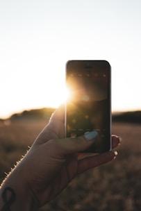 Close-up of a hand holding a smartphone with solar app