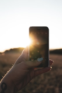 Close-up of a hand holding a smartphone with solar app