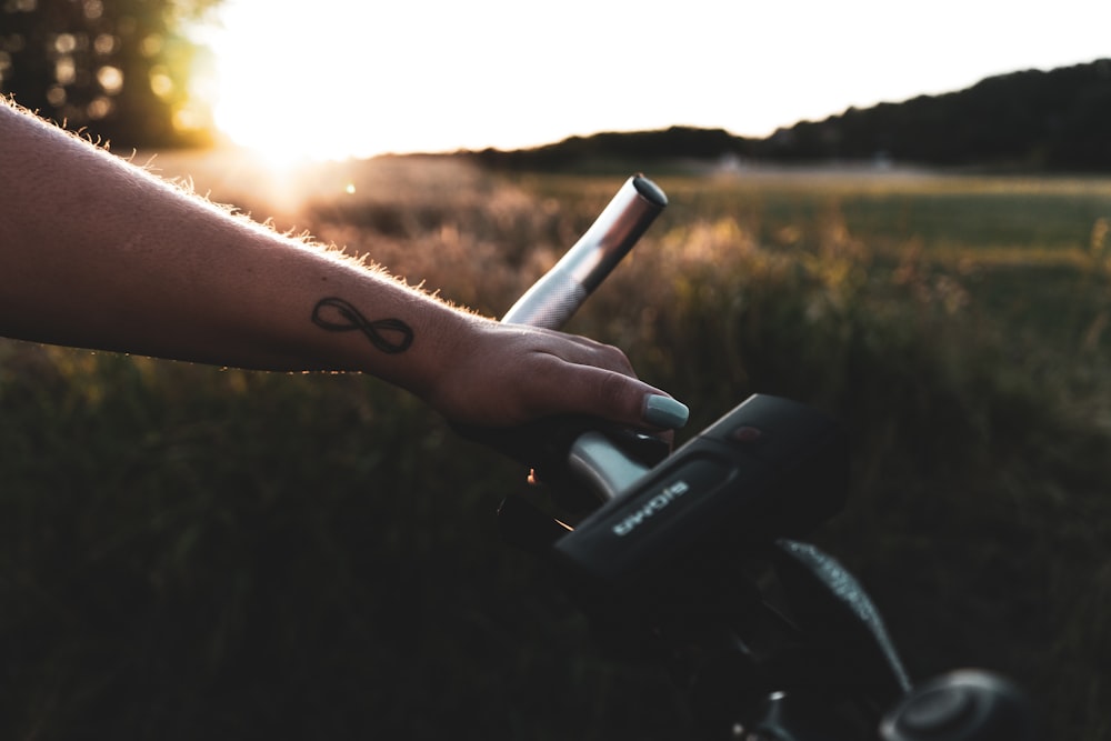 person holding bicycle handlebar during golden hour