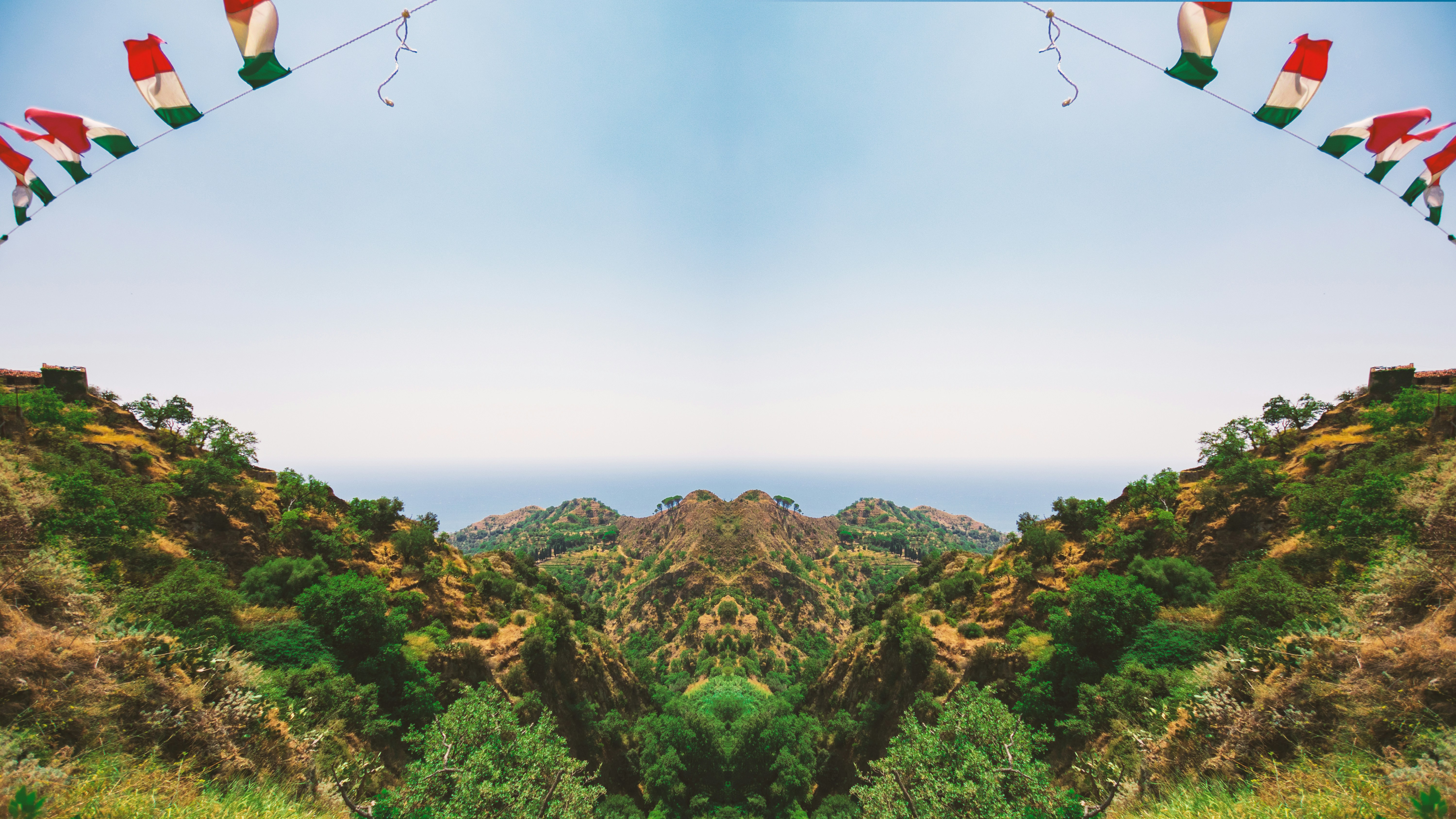 Mexico flag in a green grass lot hill during daytime