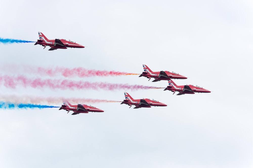 five pink planes with teal and pink smokes