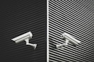 two grey CCTV cameras
