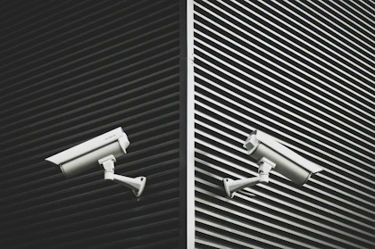 Two grey CCTV cameras on a wall
