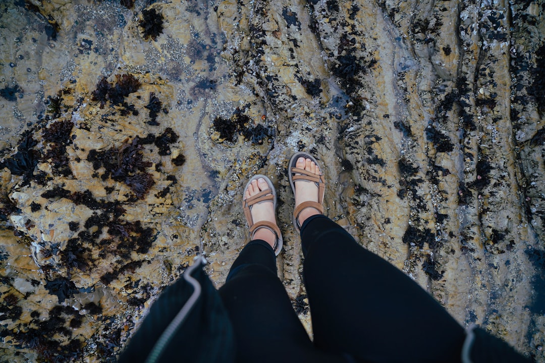 person wearing brown hiking sandals standing,