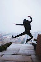 A dynamic shot of a man mid-jump in urban sportswear, with city lights blurred behind him.