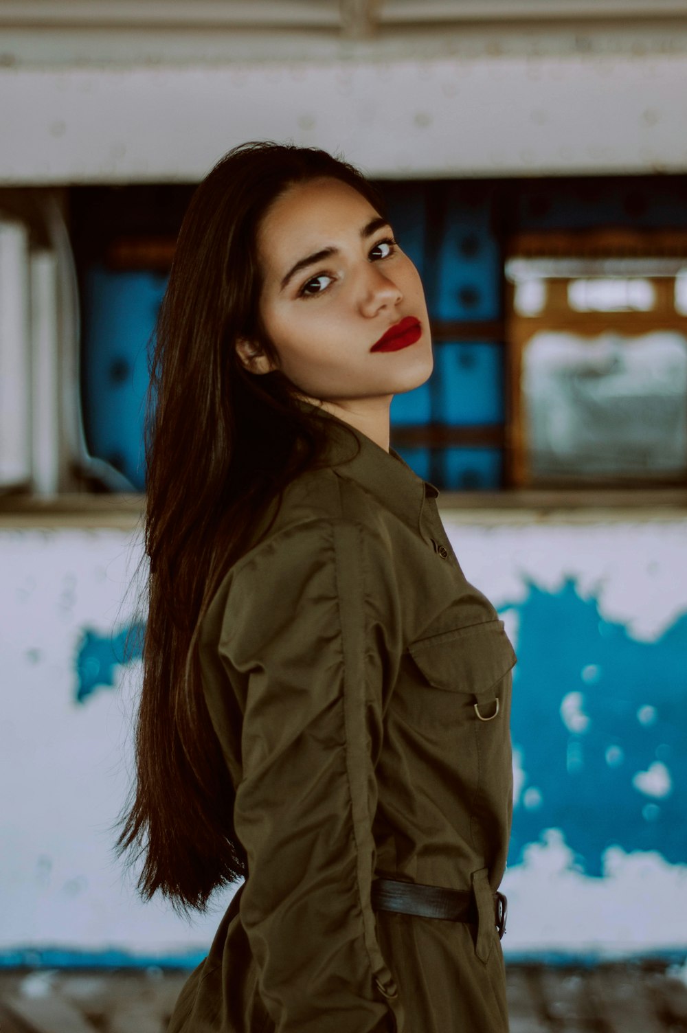 woman wearing green coat standing while glancing her right side