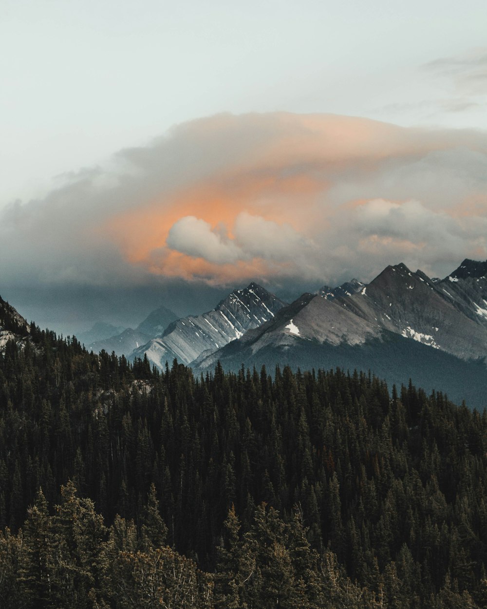 mountain covered with snow under white and orange skies