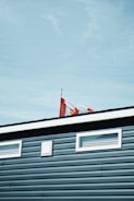 A smiling family happily holding Canadian flags outside their new home.