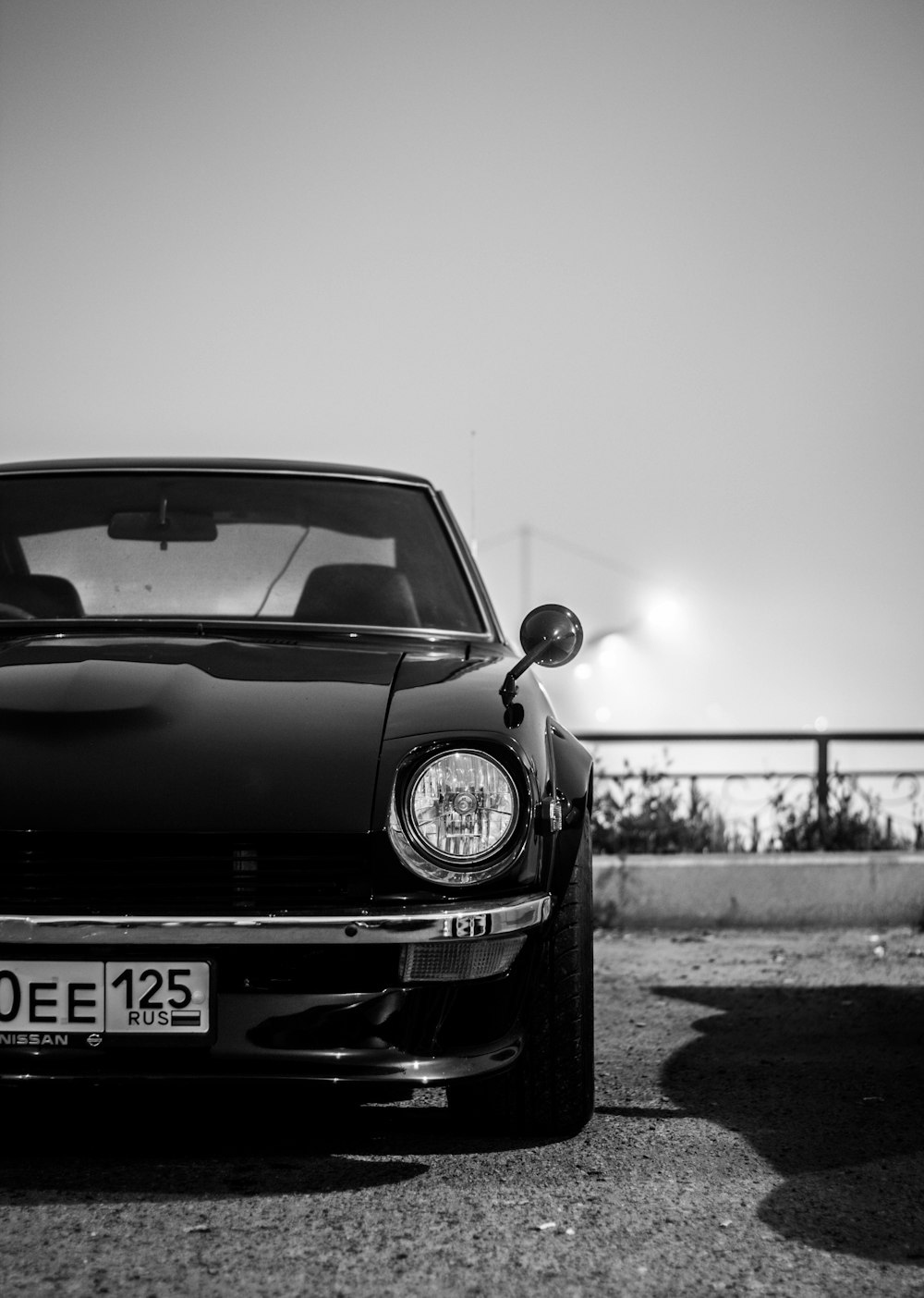 grayscale photography of car parking near road