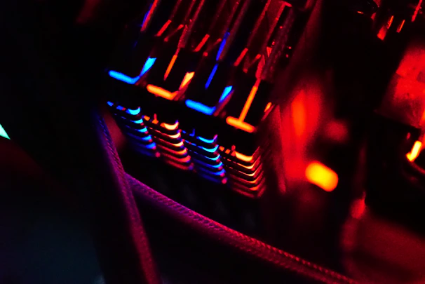 Close-up of neon-lit computer parts arranged on a dark surface with hexagonal patterns.