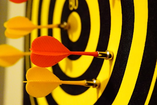 Close-up of a para darts athlete aiming with focus and determination during a competition.