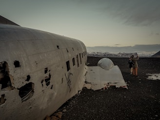 Historic airplane wreckage site in the Andes mountains with surrounding snowy peaks.