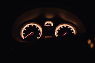 Dashboard view showing a smooth tachometer and speedometer cluster glowing with neon green highlights.