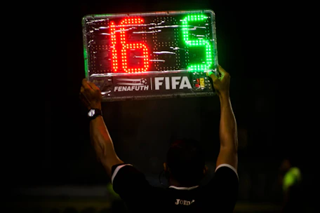 Close-up of a digital screen displaying football match statistics and predictions.