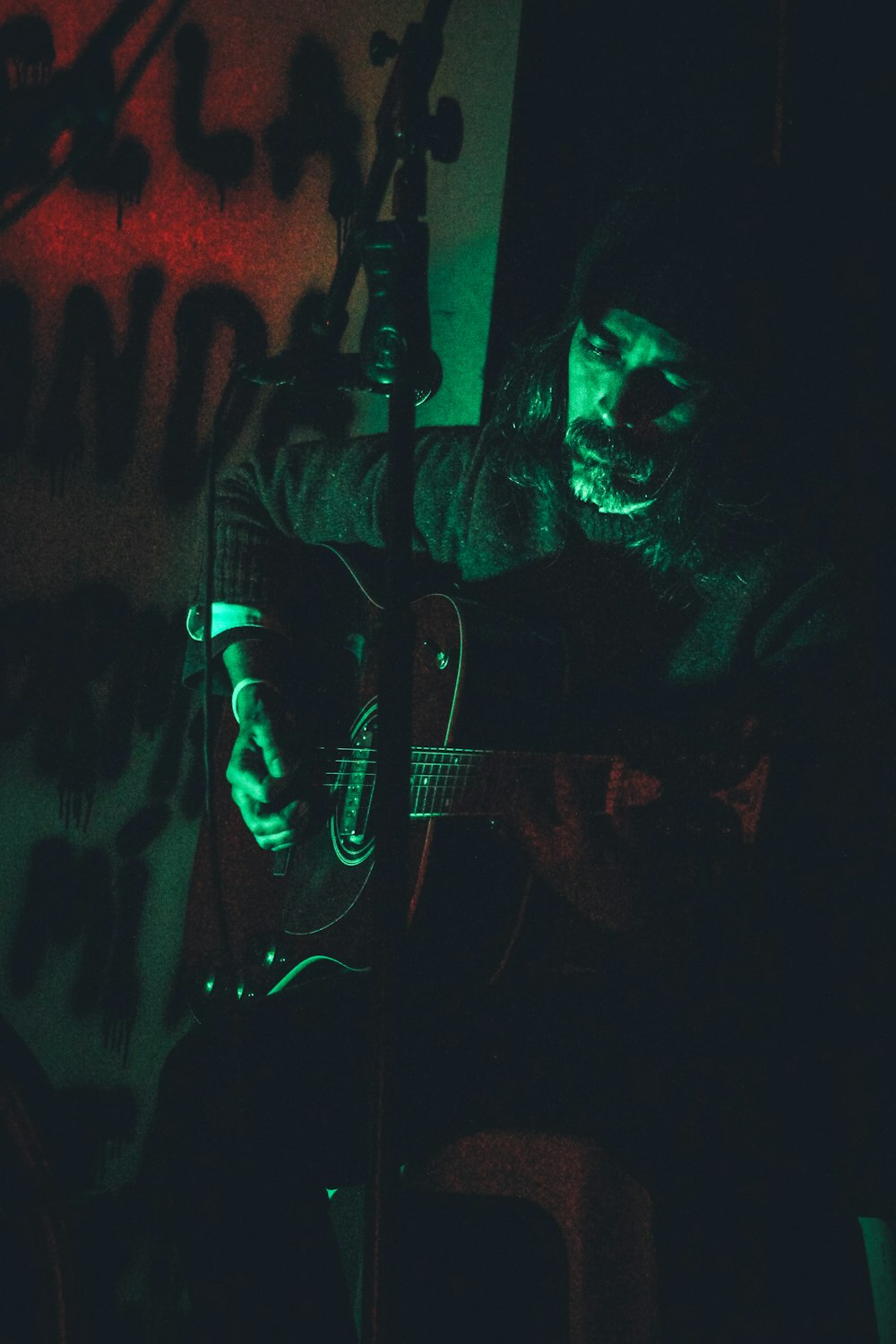 a man playing a guitar in a dark room