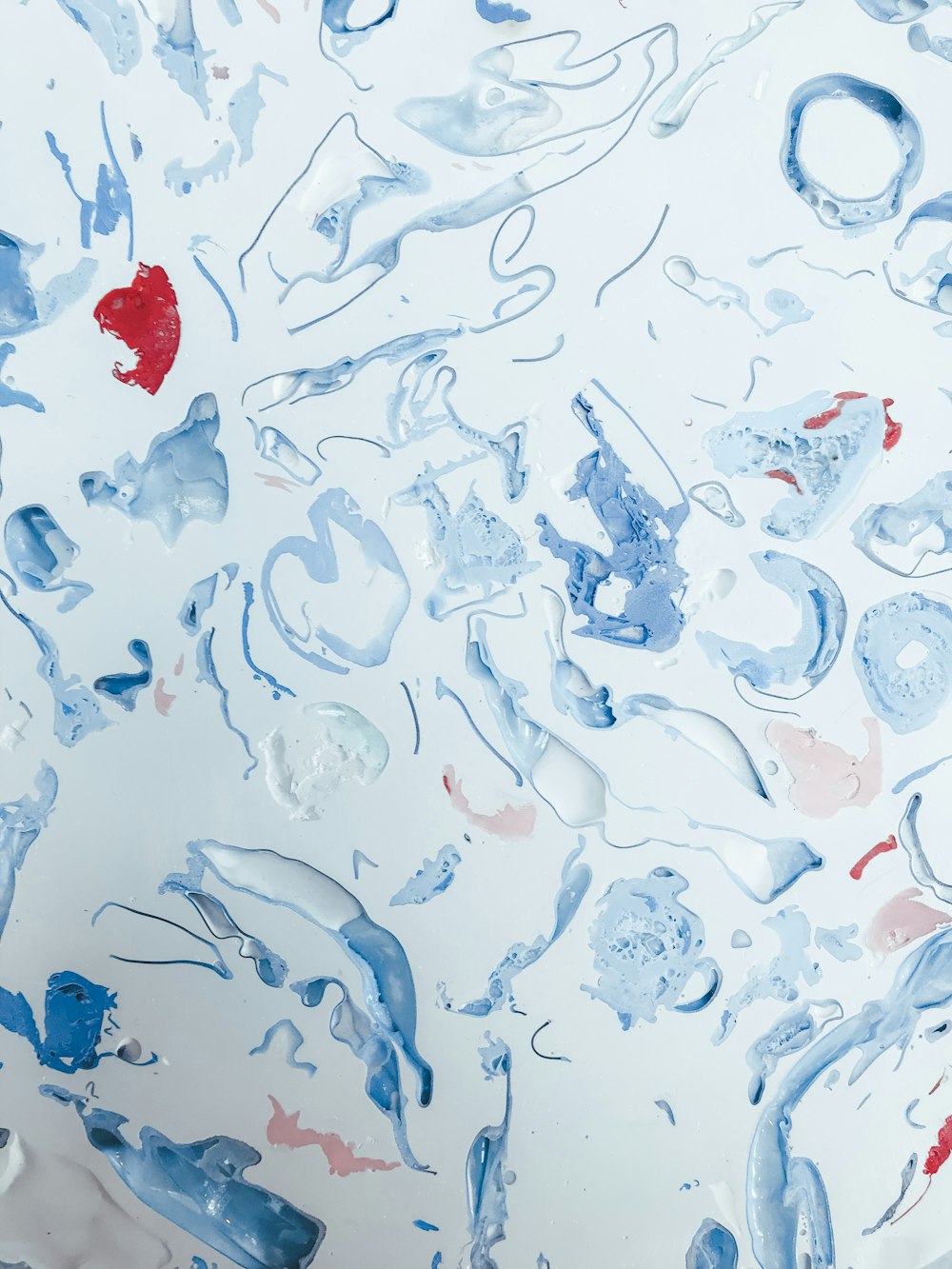 a close up of a painting with blue and red paint