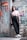 A young person wearing glasses and casual clothing leans against a graffiti-covered urban wall. The scene features a mix of textures and colors from the street art and worn surfaces, creating a vibrant, urban vibe.