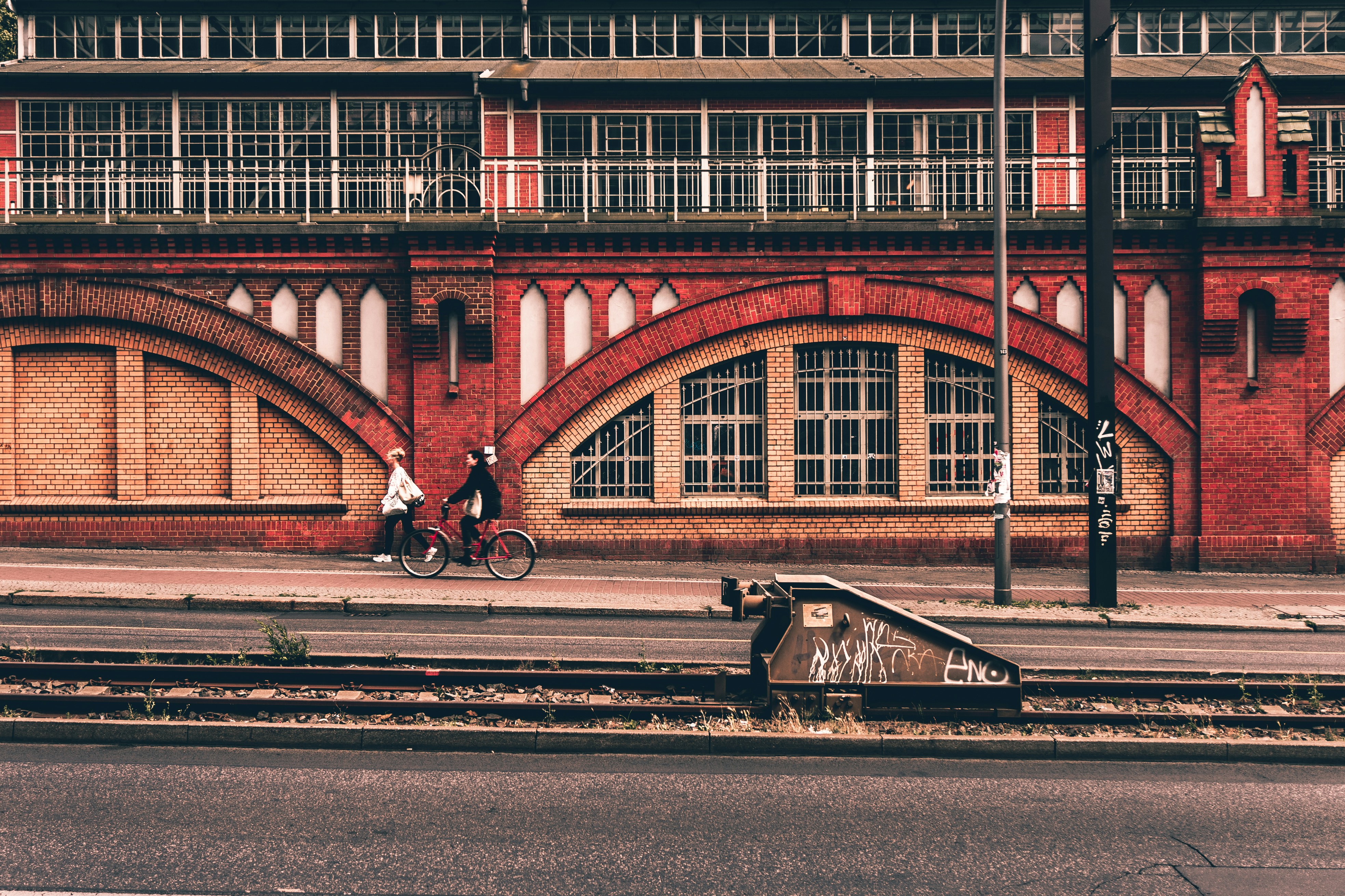 person riding bicycle near concrete building during daytime