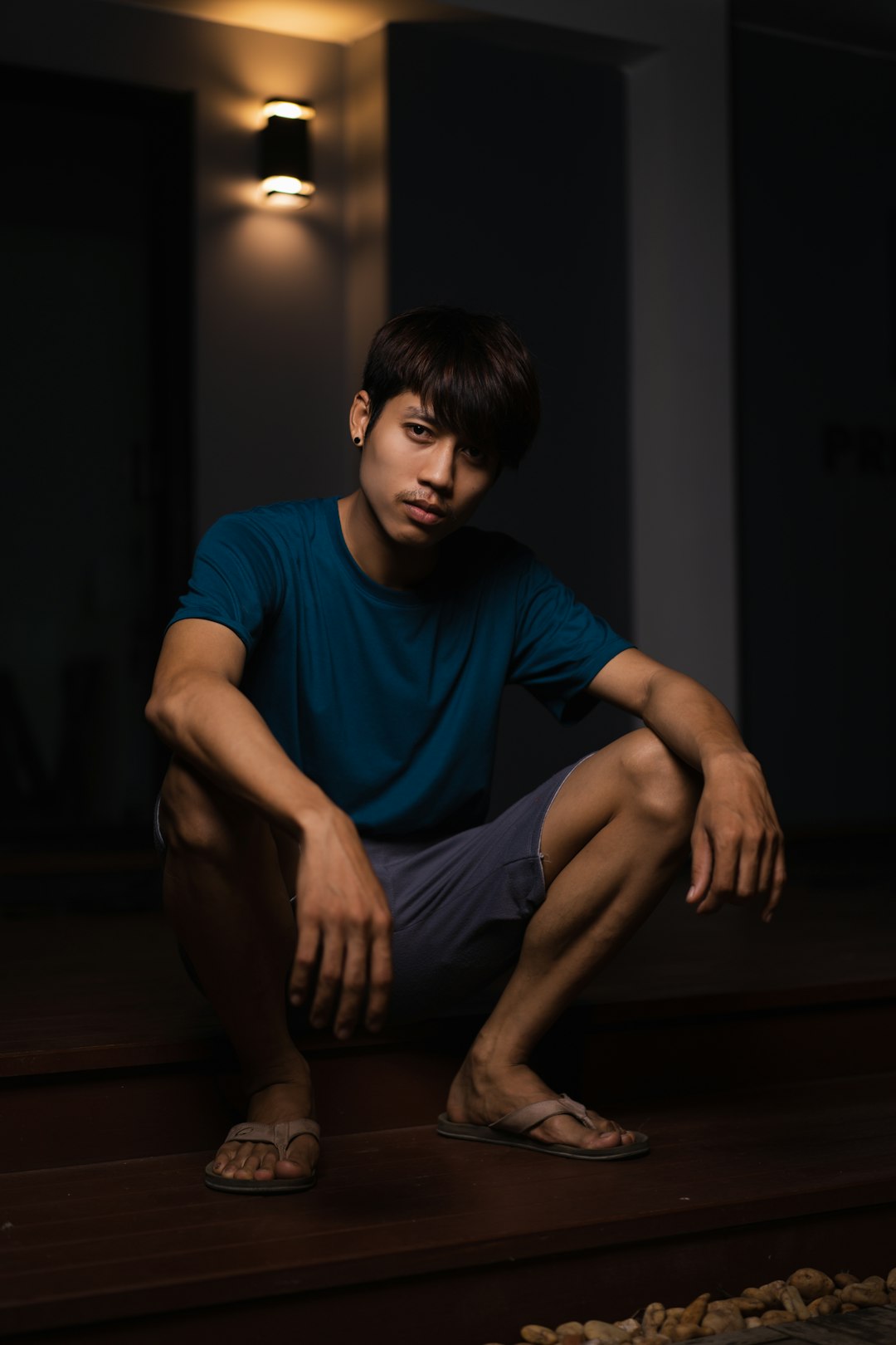 man in blue shirt sitting on floor