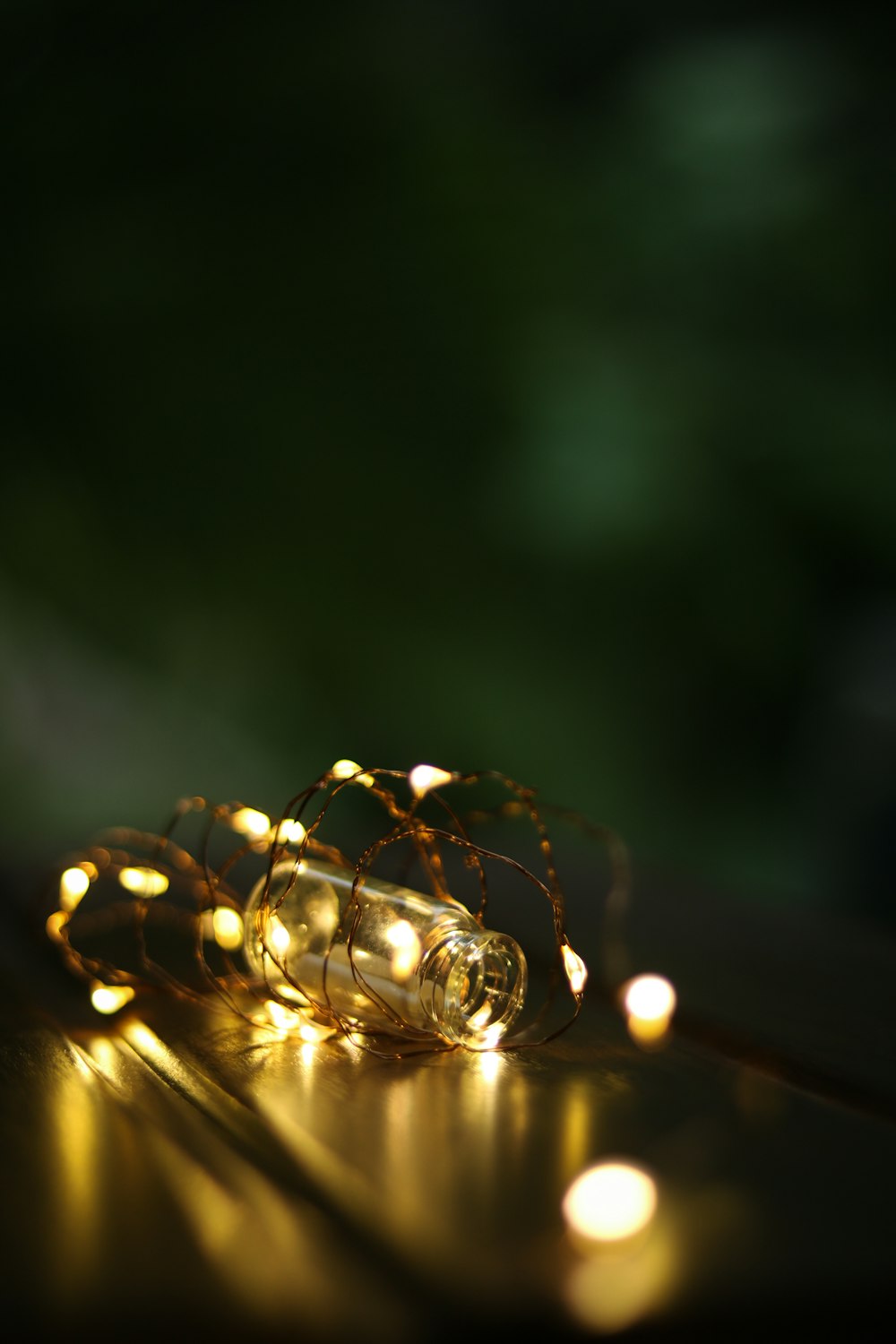 bokeh photography of yellow string lights and clear glass vial
