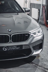 A sleek car being expertly painted in a modern workshop with advanced equipment.