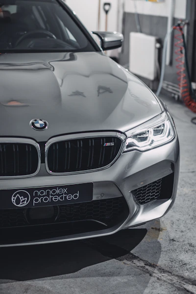 A sleek car being expertly painted in a modern workshop with advanced equipment.