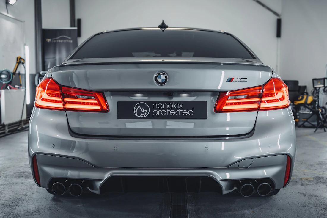 Silver BMW in a dark showroom after finish care