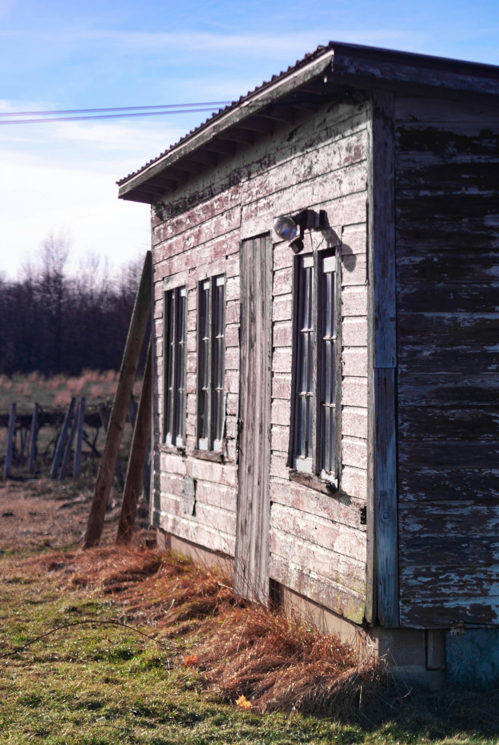 gray wooden house near green field